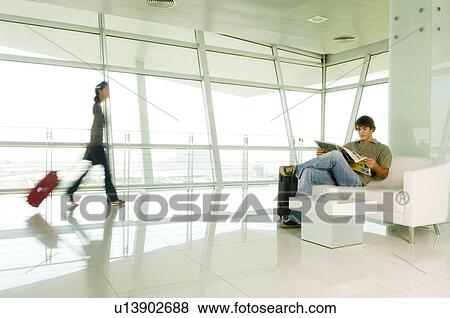 Two travellers at an airport View Large Photo Image Stock Photo - Two travellers at an airport. Fotosearch