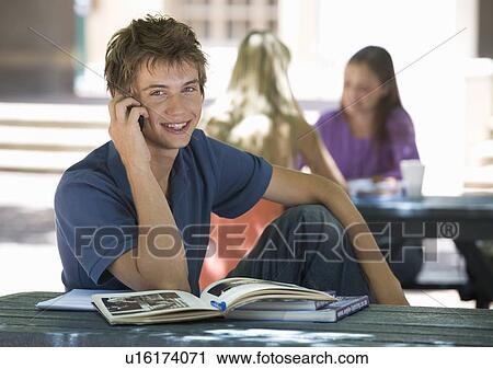 Stock Image - A university student chatting on a mobile phone. Fotosearch