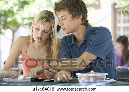 Stock Photo - Two university students helping each other with revision. Fotosearch