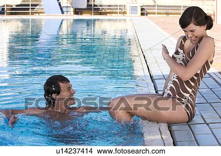 Picture - A young couple on holiday by the pool. Fotosearch