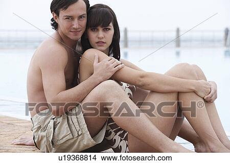 Picture - A young couple on holiday by the pool. Fotosearch