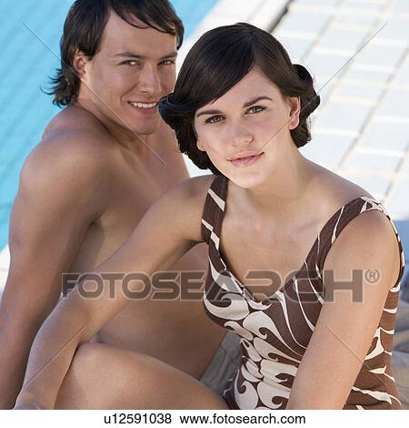 A young couple sitting by a swimming pool View Large Photo Image Stock Photo - A young couple sitting by a swimming pool. Fotosearch
