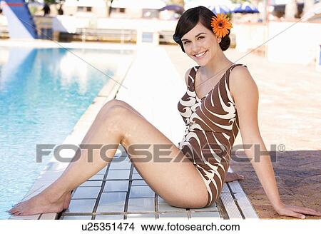 A young woman sitting by a swimming pool View Large Photo Image Picture - A young woman sitting by a swimming pool. Fotosearch