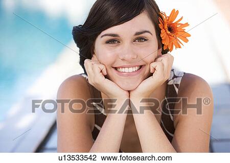 A young woman sitting by a swimming pool View Large Photo Image Stock Image - A young woman sitting by a swimming pool. Fotosearch