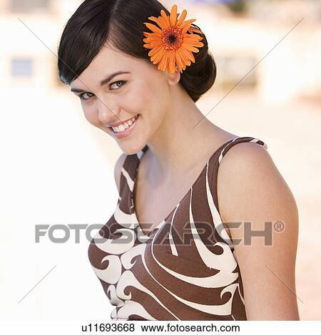 Stock Photo - A young woman standing by a swimming pool. Fotosearch