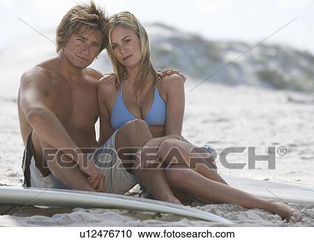 A young couple on a beach View Large Photo Image Stock Image - A young couple on a beach. Fotosearch