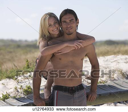Stock Image - A young couple on a beach. Fotosearch