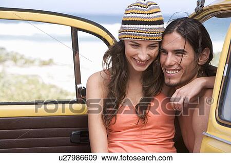 Stock Photo - A young couple on a beach. Fotosearch