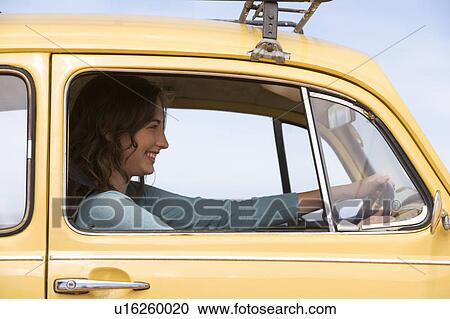 Stock Image - A young woman driving a car. Fotosearch