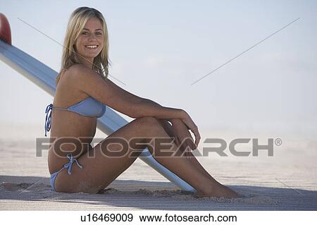 A young woman in a bikini with a surfboard View Large Photo Image Stock Photo - A young woman in a bikini with a surfboard. Fotosearch