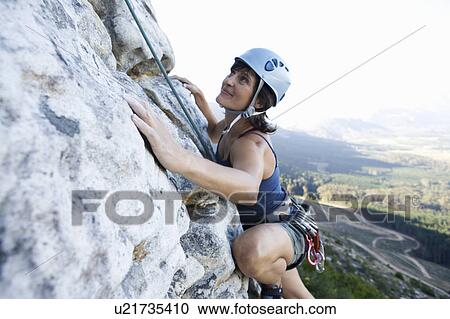Stock Image - A climber climbing a rock face. Fotosearch