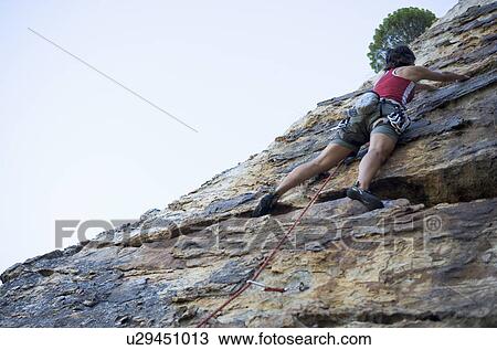 Stock Image - A climber climbing a rock face. Fotosearch