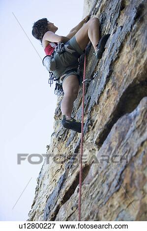 Stock Photo - A climber climbing a rock face. Fotosearch