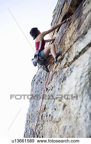 Stock Photo - A climber climbing a rock face. Fotosearch