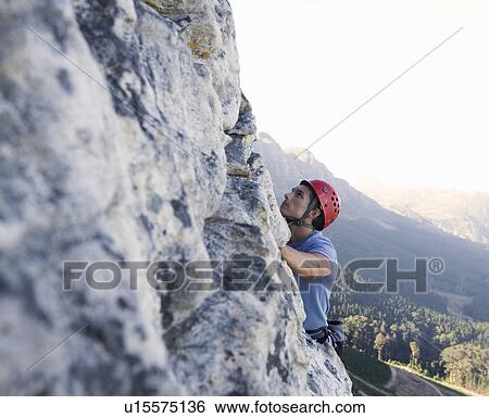 Stock Photograph - A climber climbing a rock face. Fotosearch