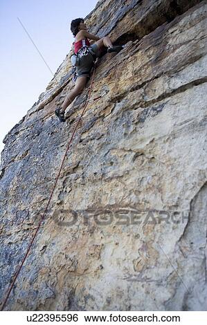 A climber climbing a rock face View Large Photo Image Stock Photograph - A climber climbing a rock face. Fotosearch