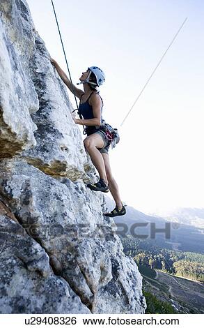A climber climbing a rock face View Large Photo Image Stock Photograph - A climber climbing a rock face. Fotosearch