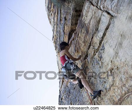 Stock Photography - A climber climbing a rock face. Fotosearch