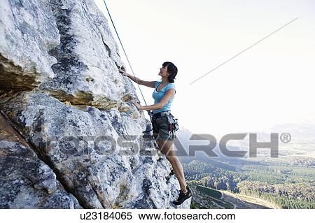 Stock Photography - A climber climbing a rock face. Fotosearch