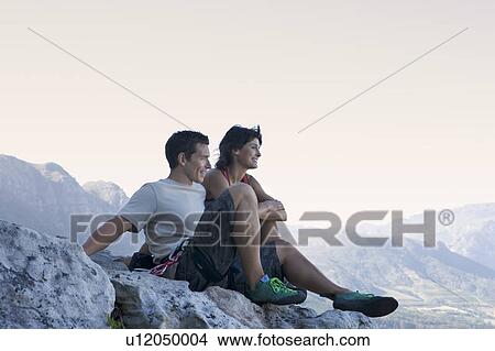 Picture - Two climbers resting at the top. Fotosearch