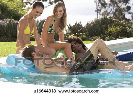 Stock Photo - Four teenage friends having fun in a swimming pool. Fotosearch