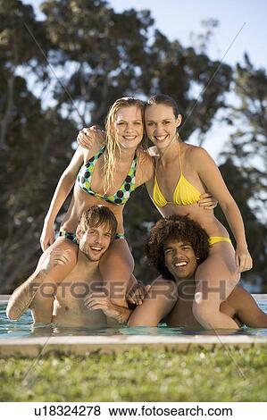 Stock Photo - Four teenage friends having fun in a swimming pool. Fotosearch