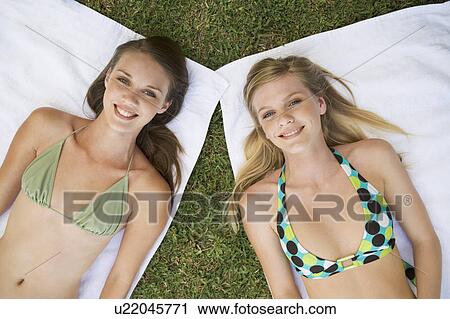 Two teenage girls sunbathing View Large Photo Image Stock Image - Two teenage girls sunbathing. Fotosearch