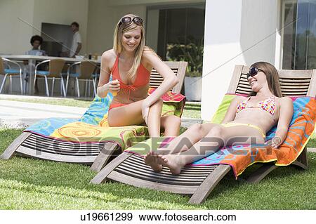 Two teenage girls sunbathing View Large Photo Image Stock Photo - Two teenage girls sunbathing. Fotosearch