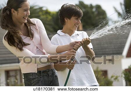 A brother and sister playing with a hose pipe View Large Photo Image Stock Image - A brother and sister playing with a hose pipe. Fotosearch
