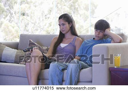 Stock Photography - A brother and sister watching TV. Fotosearch