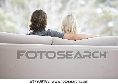 Stock Image - A couple sitting on a sofa. Fotosearch
