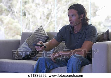 Stock Image - A man using a remote control. Fotosearch