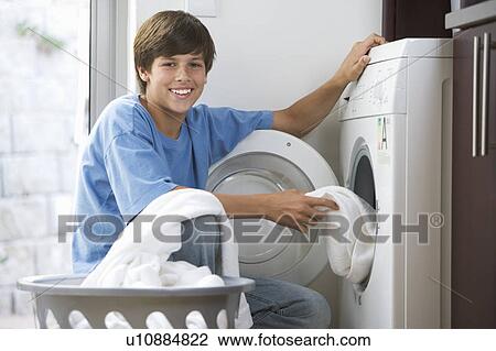 A young boy loading the washing machine View Large Photo Image Stock Image - A young boy loading the washing machine. Fotosearch