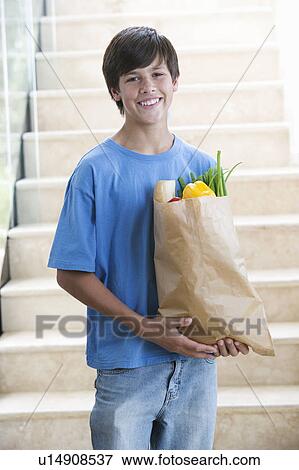 A young boy with a bag of shopping View Large Photo Image Stock Photo - A young boy with a bag of shopping. Fotosearch