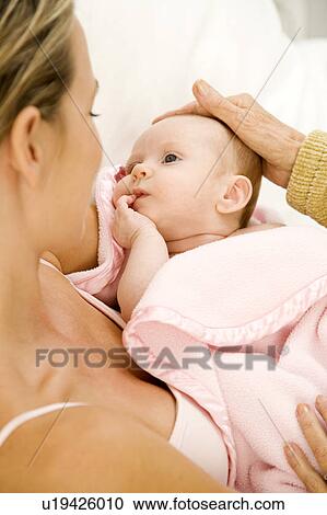 Stock Image - A grandmother greeting her new grandchild after the birth. Fotosearch