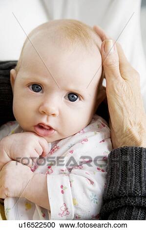 Stock Image - A grandmother holding her new grandchild. Fotosearch