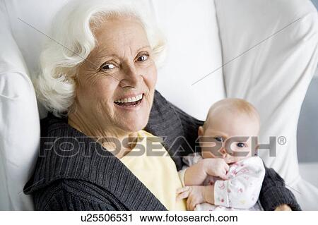 Stock Image - A grandmother holding her new grandchild. Fotosearch