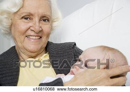 Stock Photo - A grandmother holding her new grandchild. Fotosearch