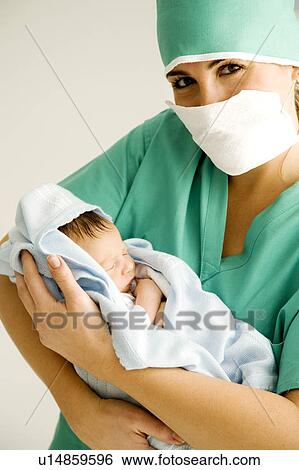 A medical practitioner holding a newborn baby View Large Photo Image Stock Photograph - A medical practitioner holding a newborn baby. Fotosearch
