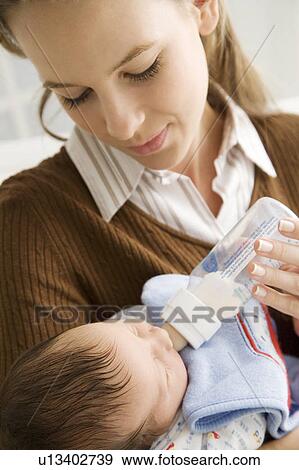 A mother bottle feeding her baby View Large Photo Image Stock Photo - A mother bottle feeding her baby. Fotosearch
