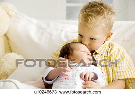 A young boy with his new sibling View Large Photo Image Stock Image - A young boy with his new sibling. Fotosearch