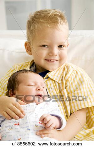 Stock Image - A young boy with his new sibling. Fotosearch
