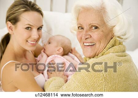 Picture - Grandmother greeting her new grandchild after the birth. Fotosearch