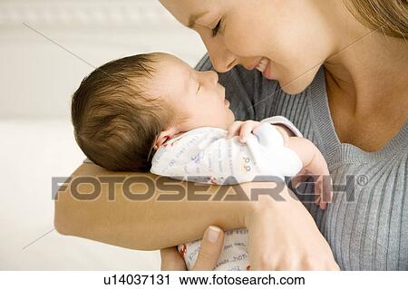 Mother holding her young baby View Large Photo Image Stock Image - Mother holding her young baby. Fotosearch