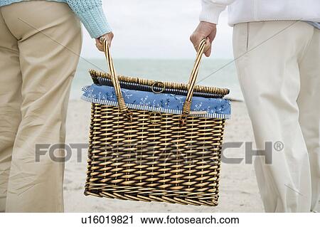 A senior couple carrying a picnic basket View Large Photo Image Stock Image - A senior couple carrying a picnic basket. Fotosearch