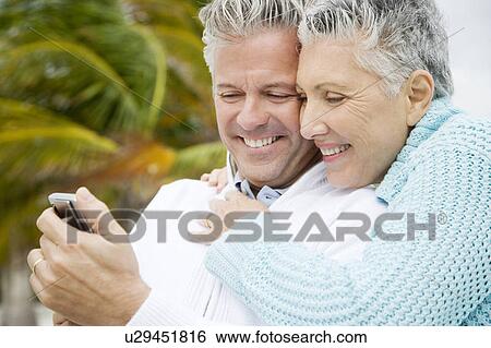 A senior couple reading a text message View Large Photo Image Stock Photograph - A senior couple reading a text message. Fotosearch