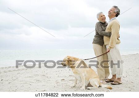 Stock Image - A senior couple walking their dog. Fotosearch