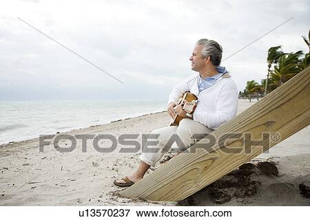A senior man playing a guitar View Large Photo Image Stock Photo - A senior man playing a guitar. Fotosearch