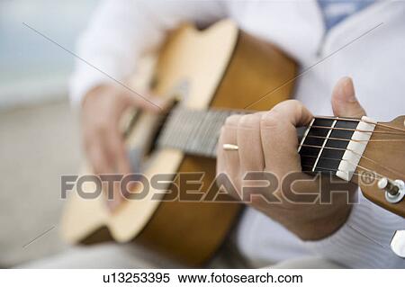 A senior man playing a guitar View Large Photo Image Stock Photography - A senior man playing a guitar. Fotosearch