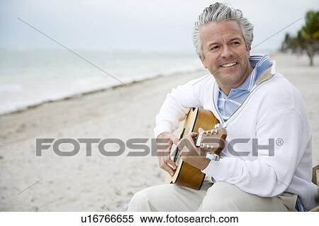 Stock Photography - A senior man playing a guitar. Fotosearch
